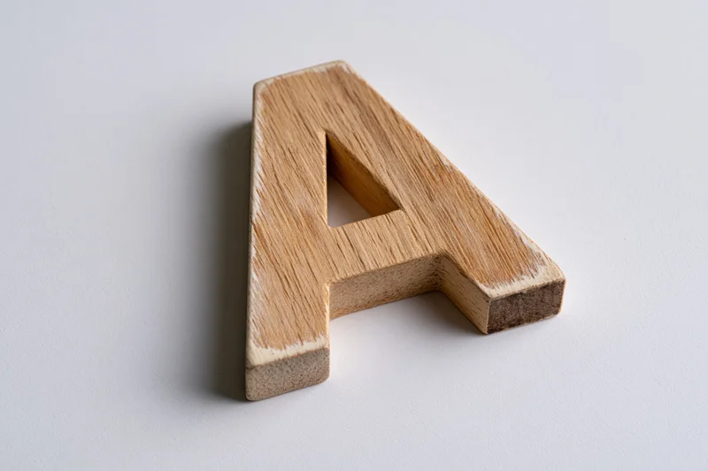 Wooden letter a block lying flat on white surface