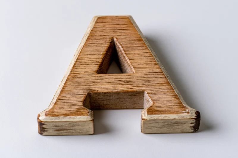 Wooden letter a toy block lying flat on white background