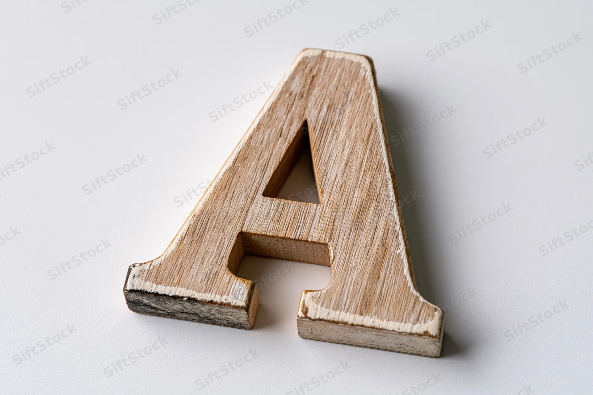 Wooden letter a block lying flat centered on white background