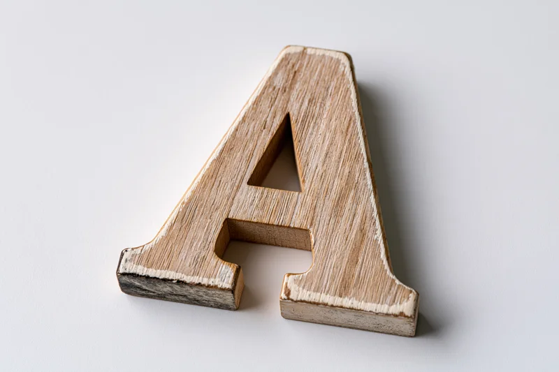 Wooden letter a block lying flat centered on white background