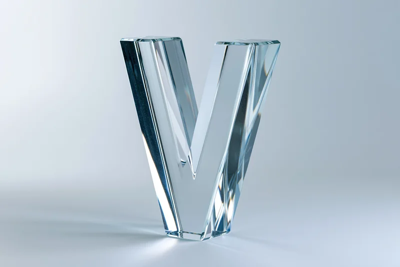Glass letter v sculpture standing upright on white background
