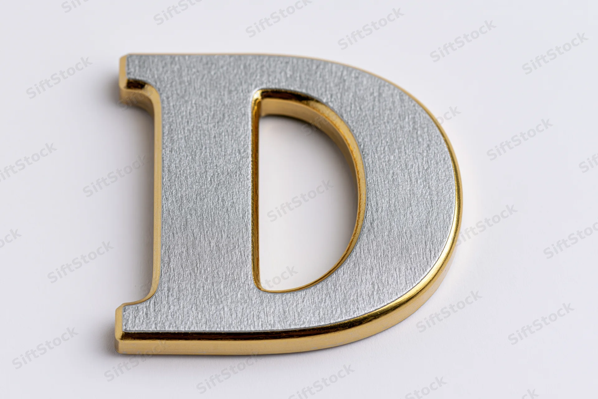 Three-dimensional uppercase letter d with matte silver face and gold edges on white background