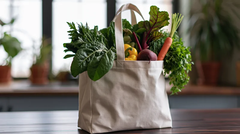 Canvas tote bag filled with fresh vegetables on wooden kitchen table