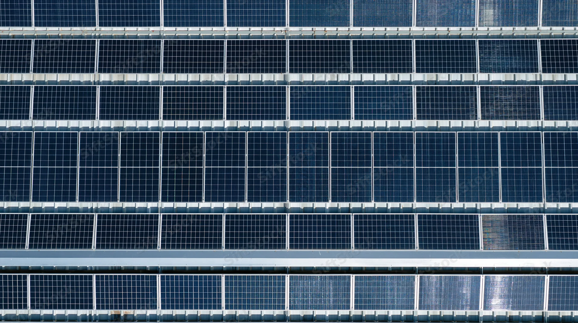 Aerial view of rows of solar panels on a rooftop installation