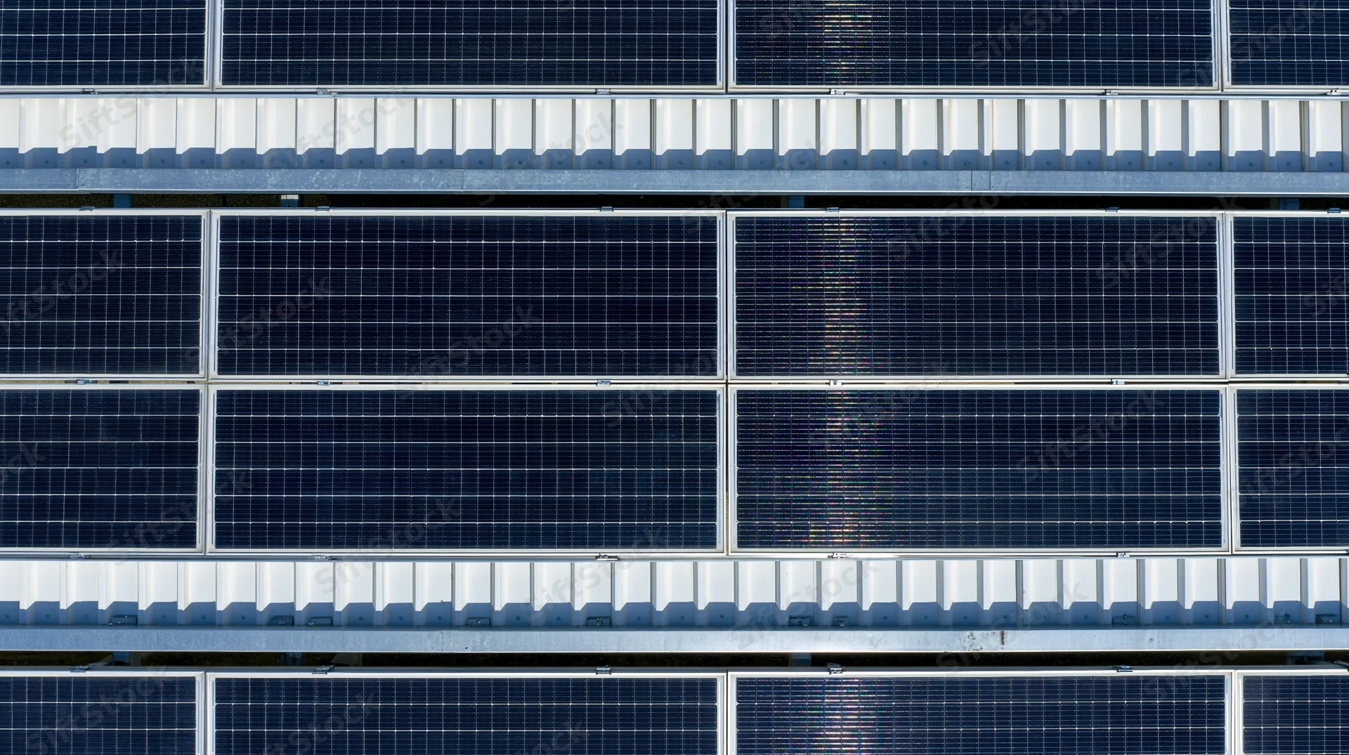 Aerial view of rows of solar panels on a rooftop installation