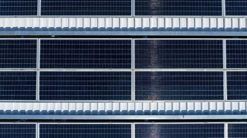 Aerial view of rows of solar panels on a rooftop installation
