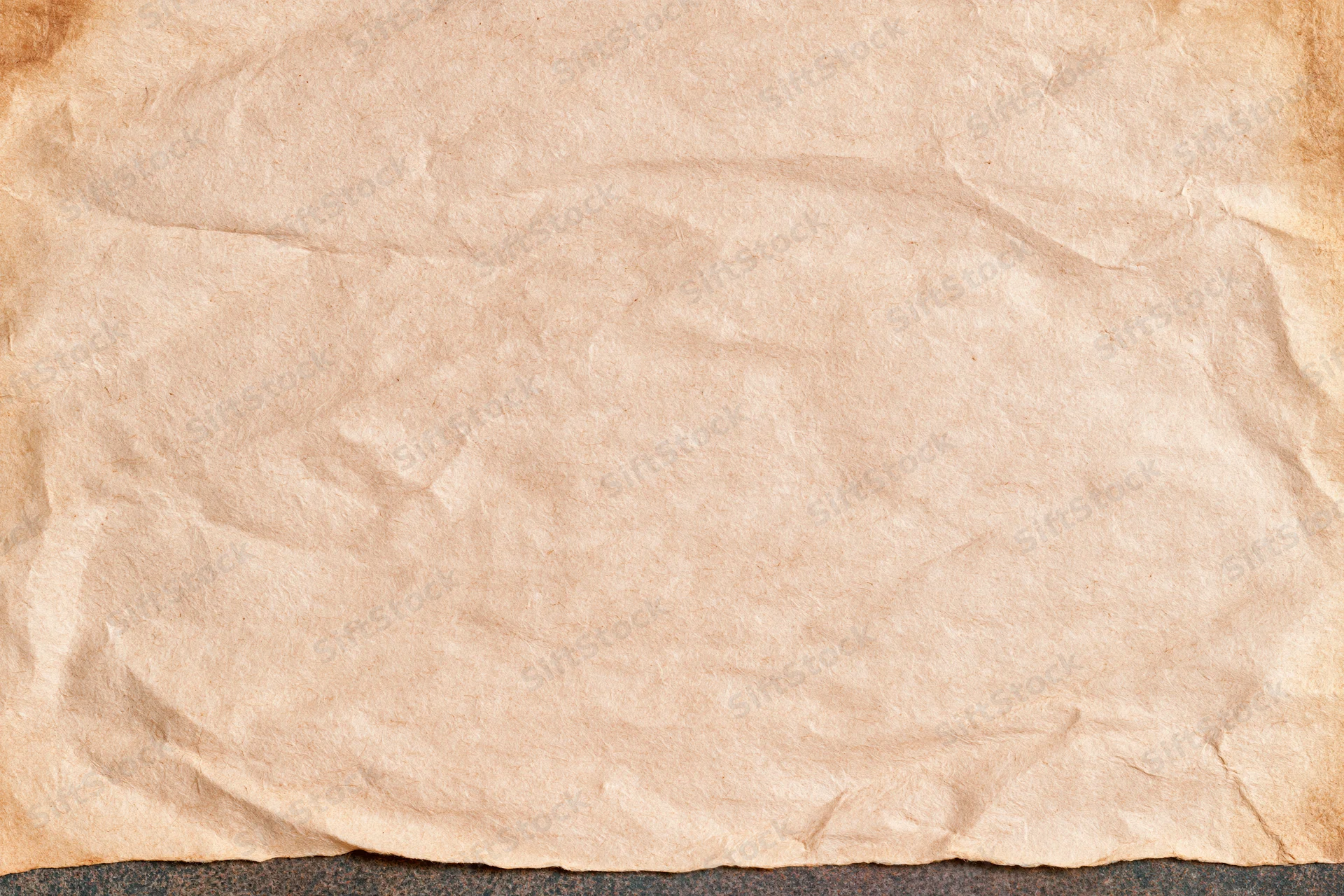 Closeup of aged crumpled paper sheet with textured surface lying flat