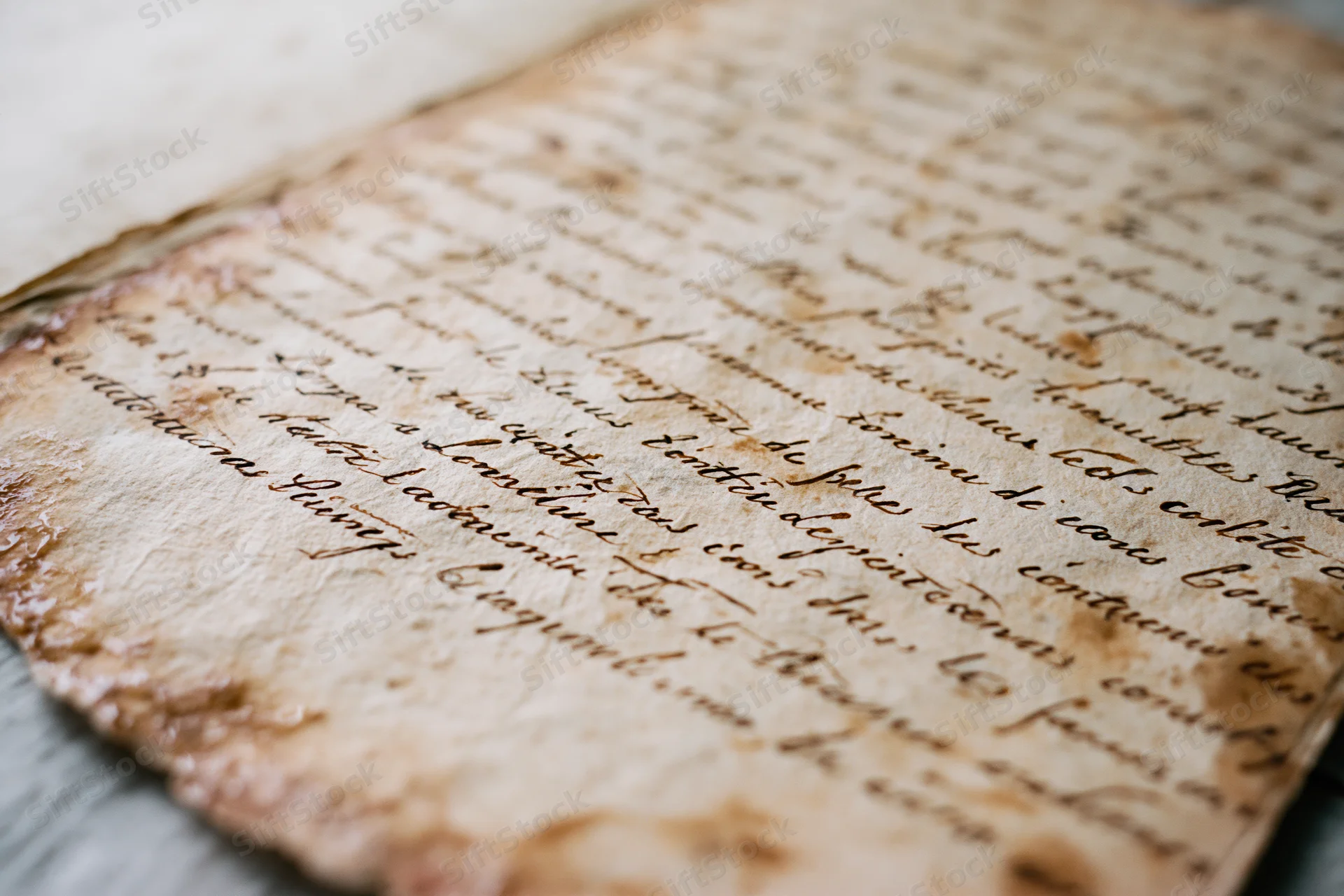 Close-up of aged handwritten french cursive document on textured parchment paper