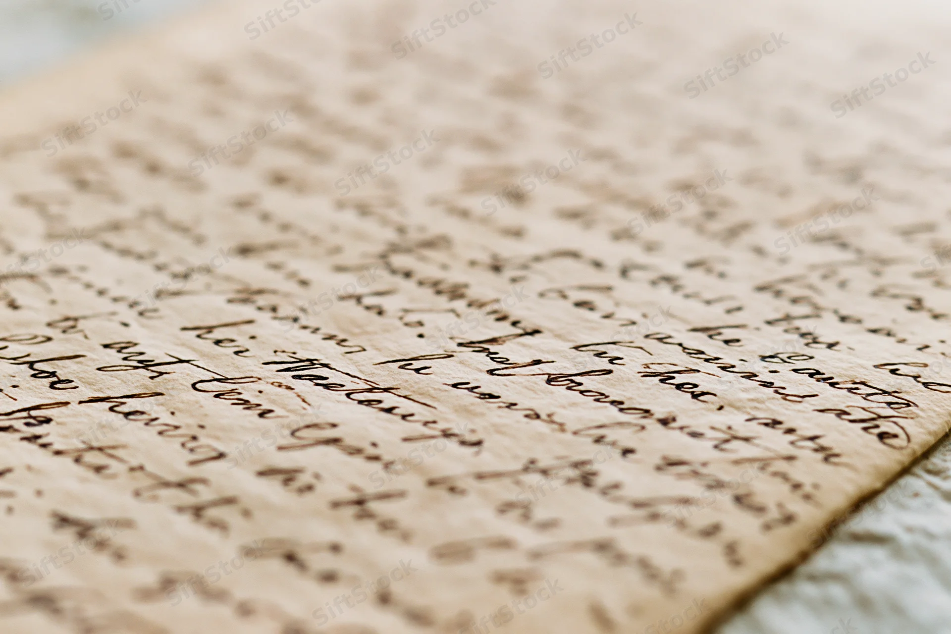 Close-up of an aged handwritten letter in cursive script on textured paper