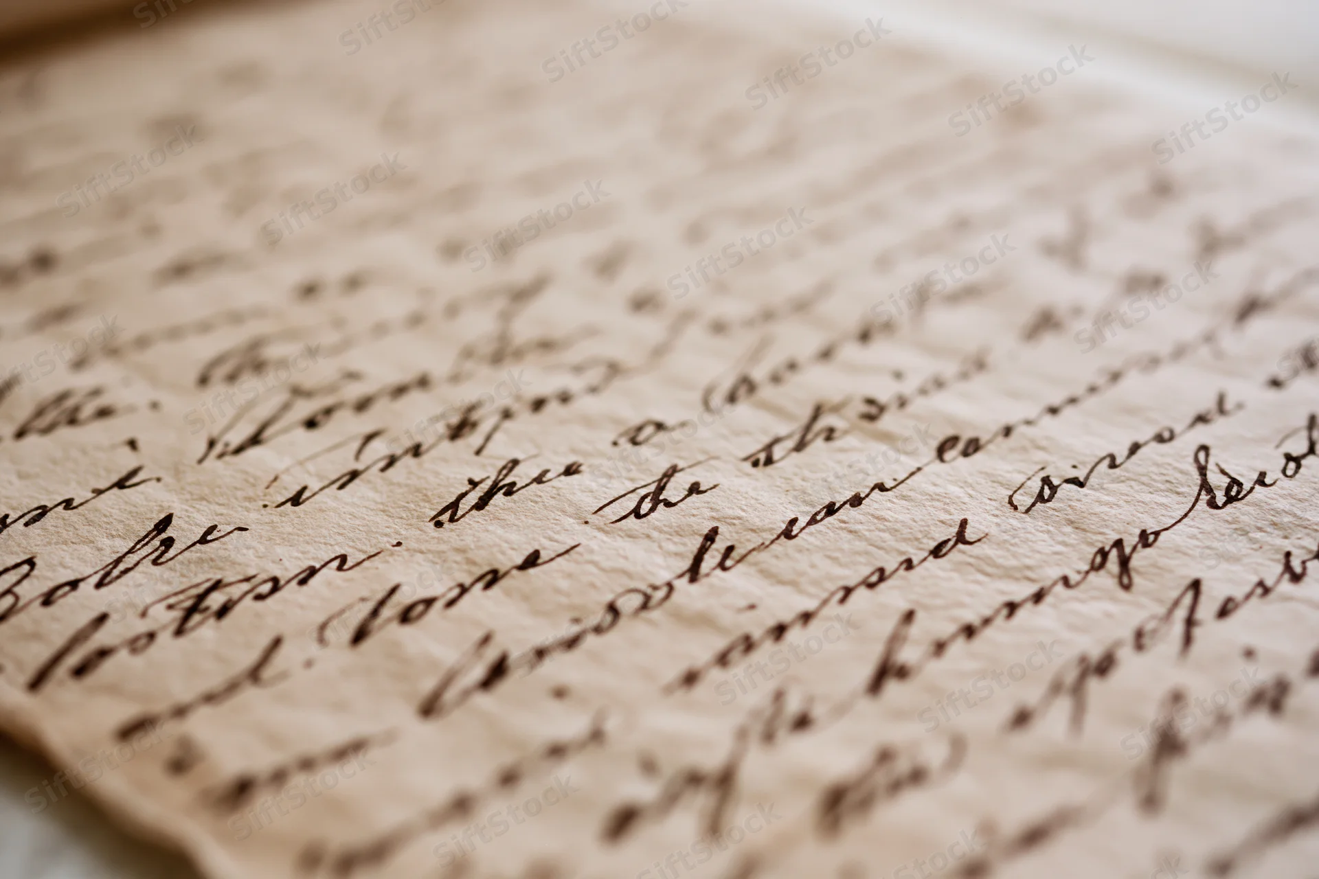 Close-up of an aged handwritten letter in cursive script on textured paper