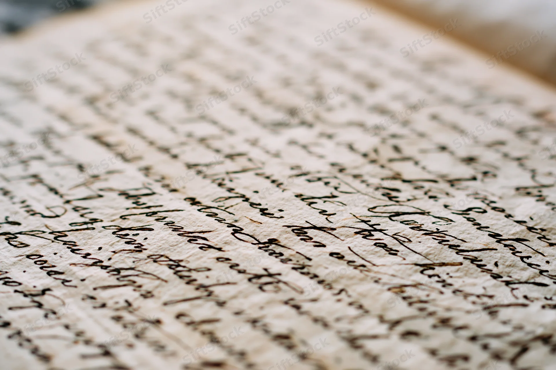 Close-up of aged handwritten letter in cursive script on textured paper