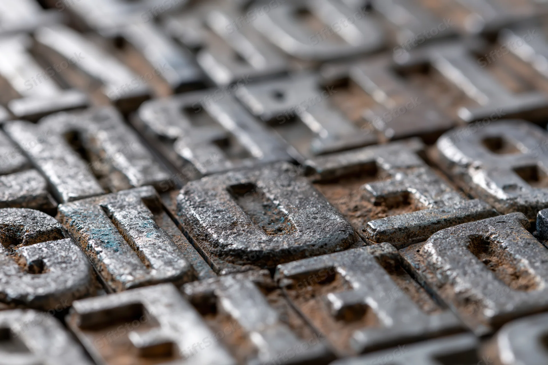 Closeup of antique metal letterpress type blocks arranged densely in a grid pattern