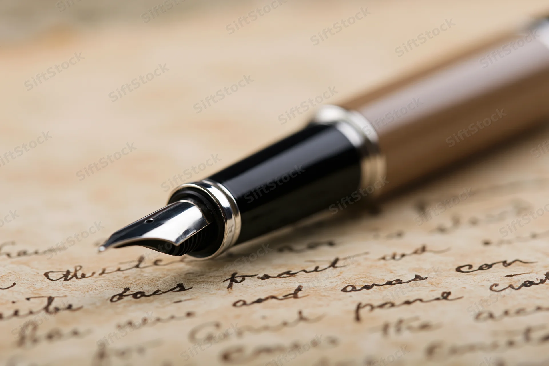 Fountain pen resting on aged handwritten letter with cursive script
