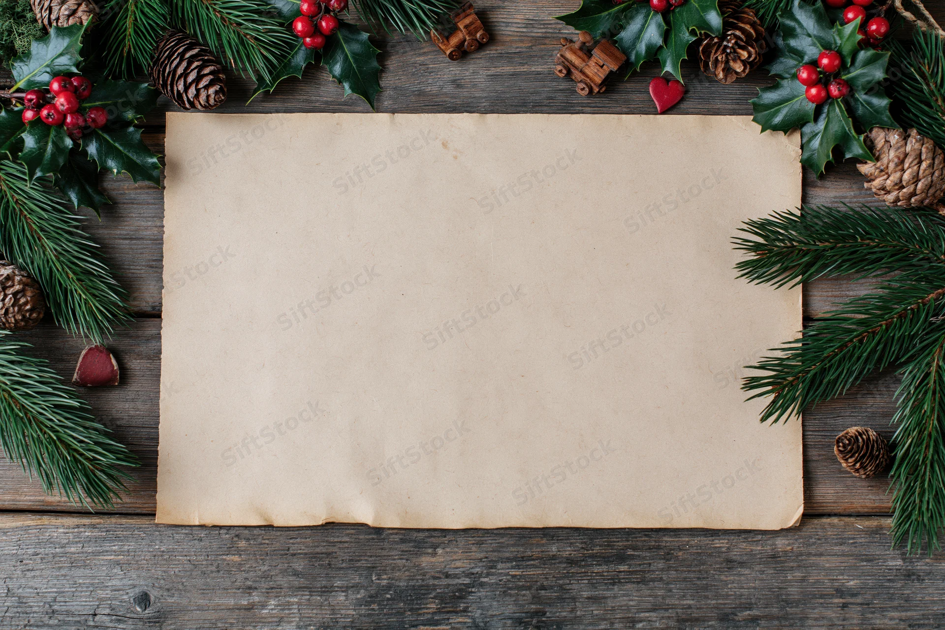 Blank aged kraft paper sheet framed by christmas decorations on weathered wood