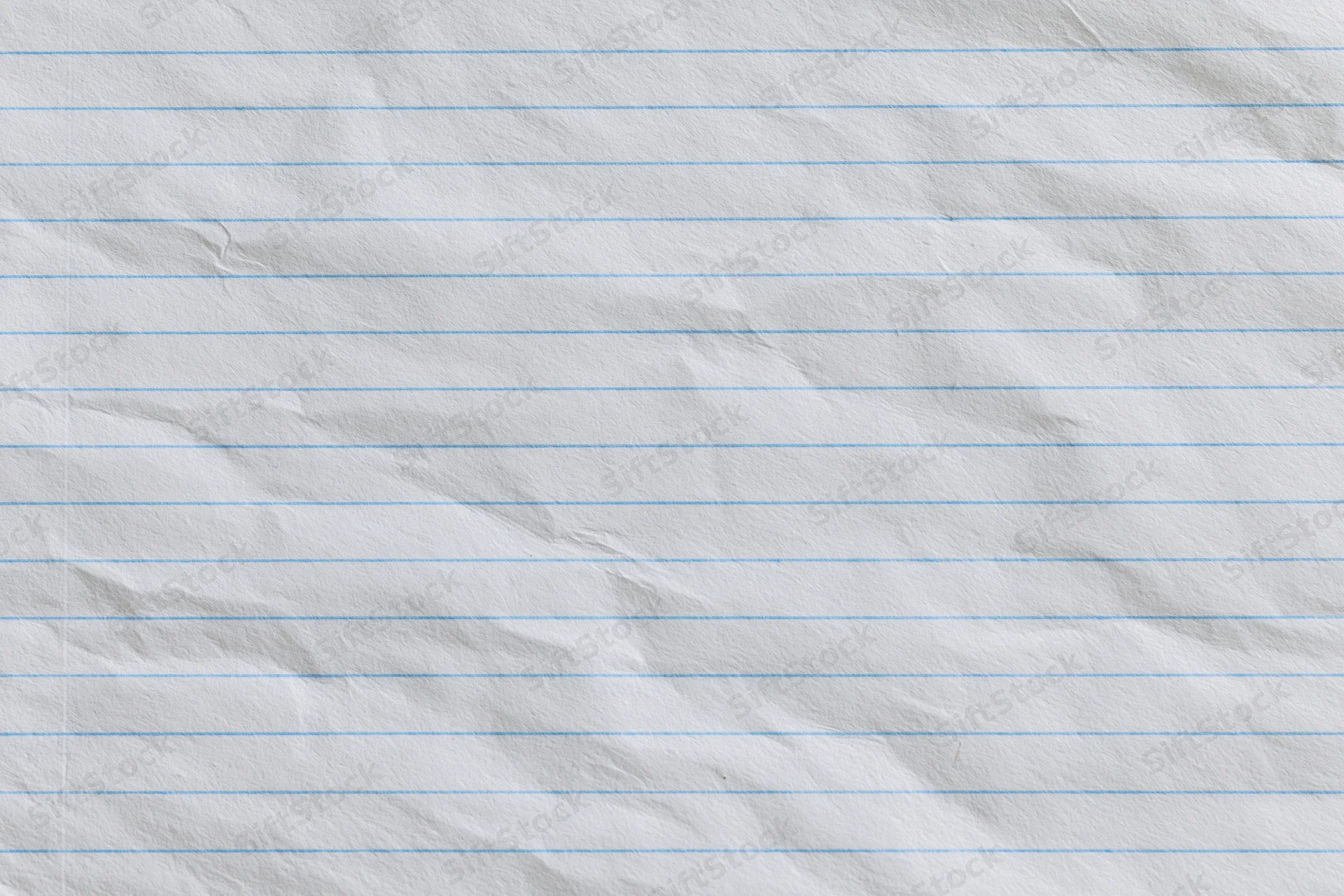Crumpled lined notebook paper with blue horizontal lines filling the frame
