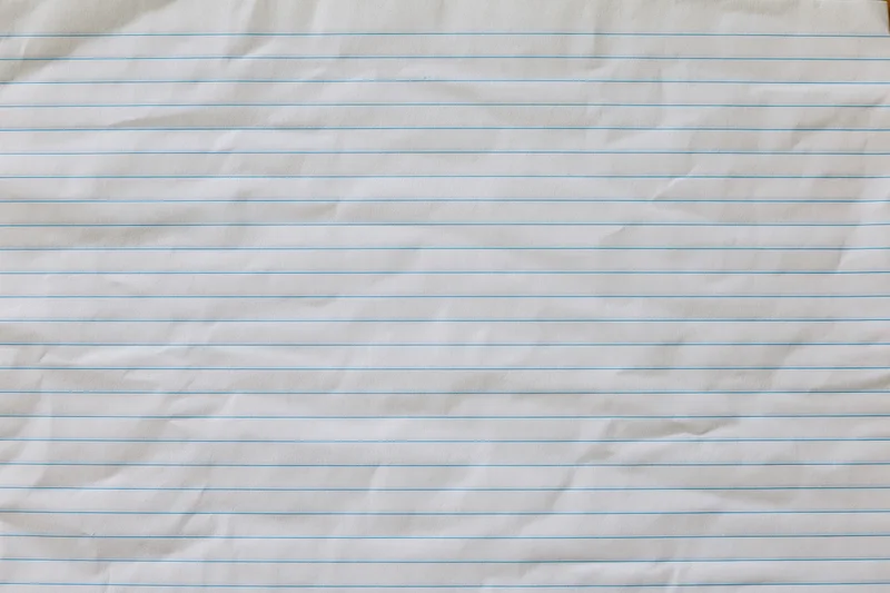 Crumpled lined notebook paper filling the frame as a textured background with copy space