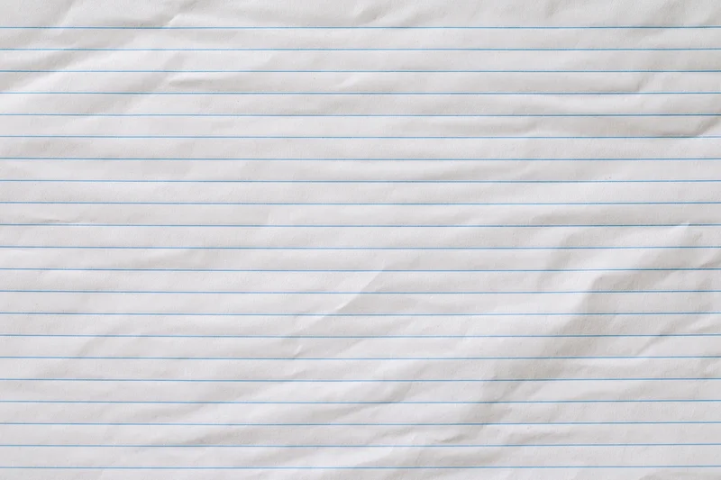 Crumpled lined notebook paper filling the frame as a textured background