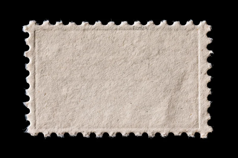 Blank postage stamp with perforated edges on black background