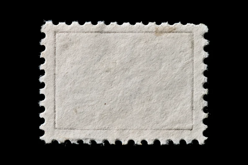 Blank postage stamp with perforated edges on black background