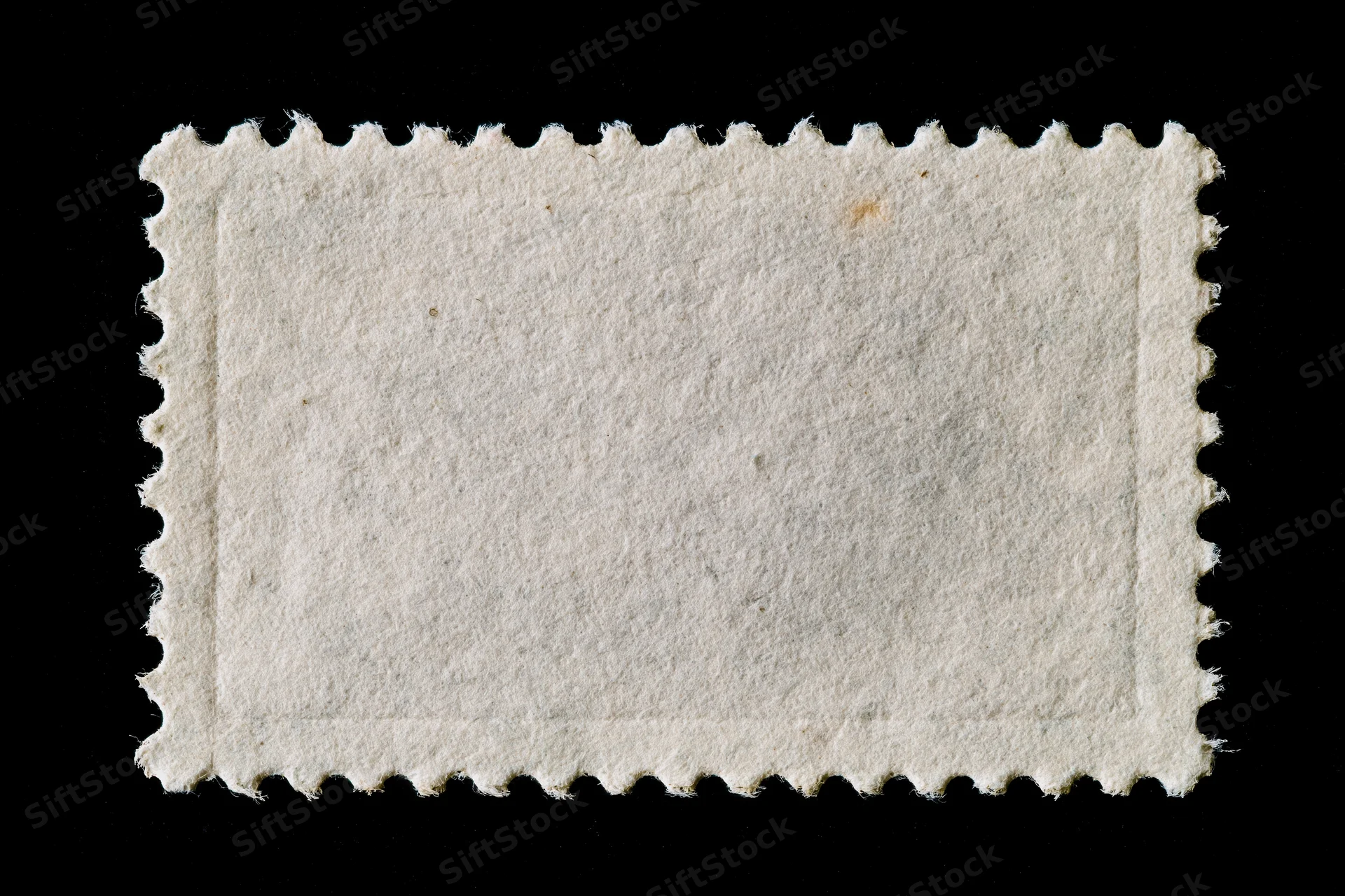 Blank postage stamp with perforated edges on black background