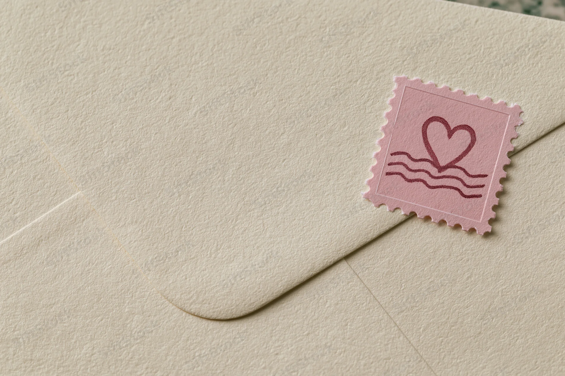 Cream textured vintage envelope with pink heart stamp in corner