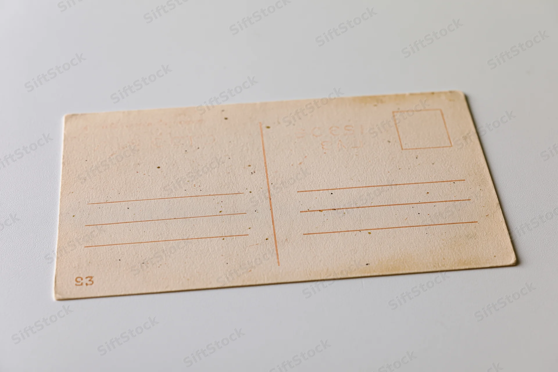 Vintage blank postcard back side lying flat on white surface with address lines and stamp box