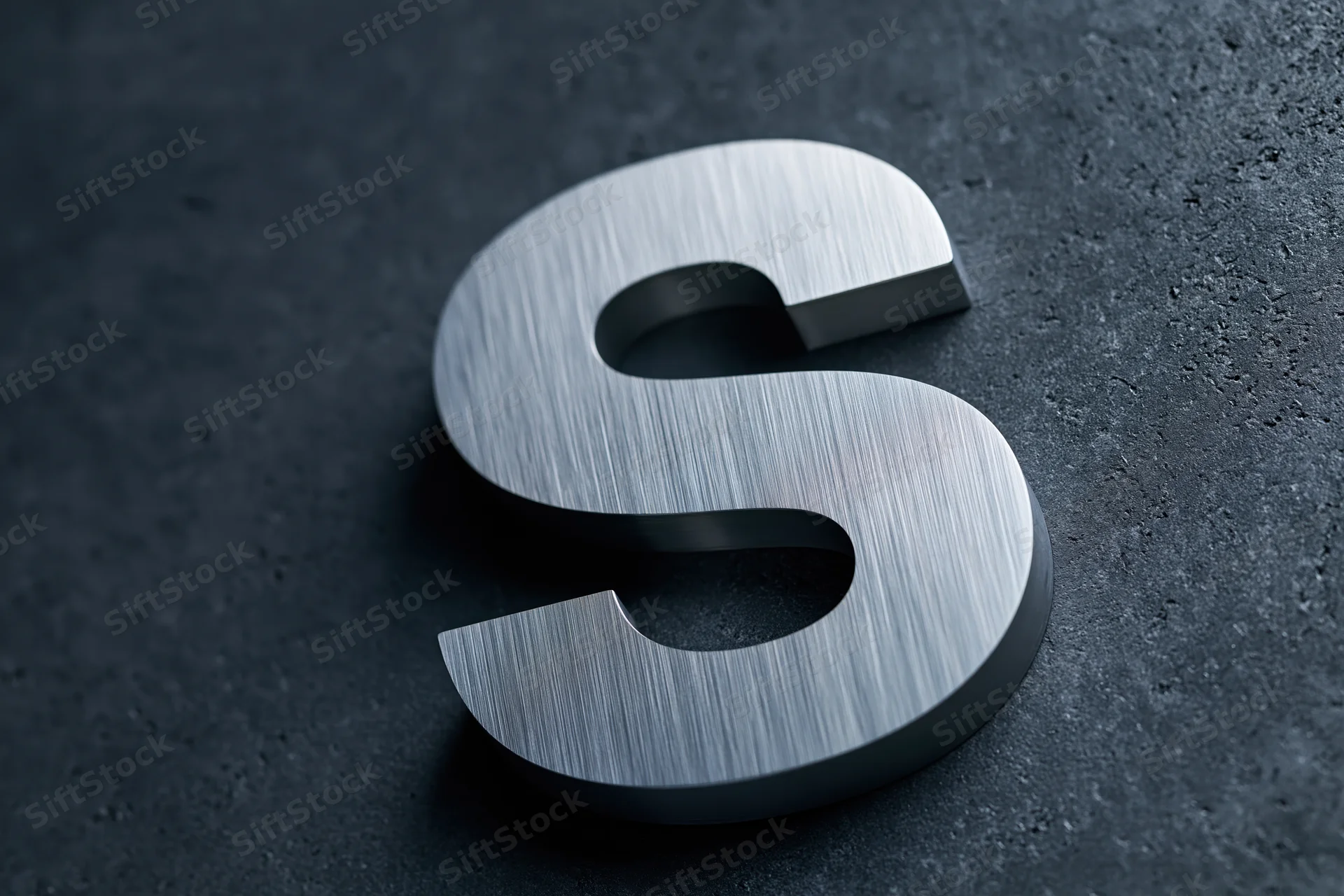 Brushed stainless steel letter s on dark textured surface