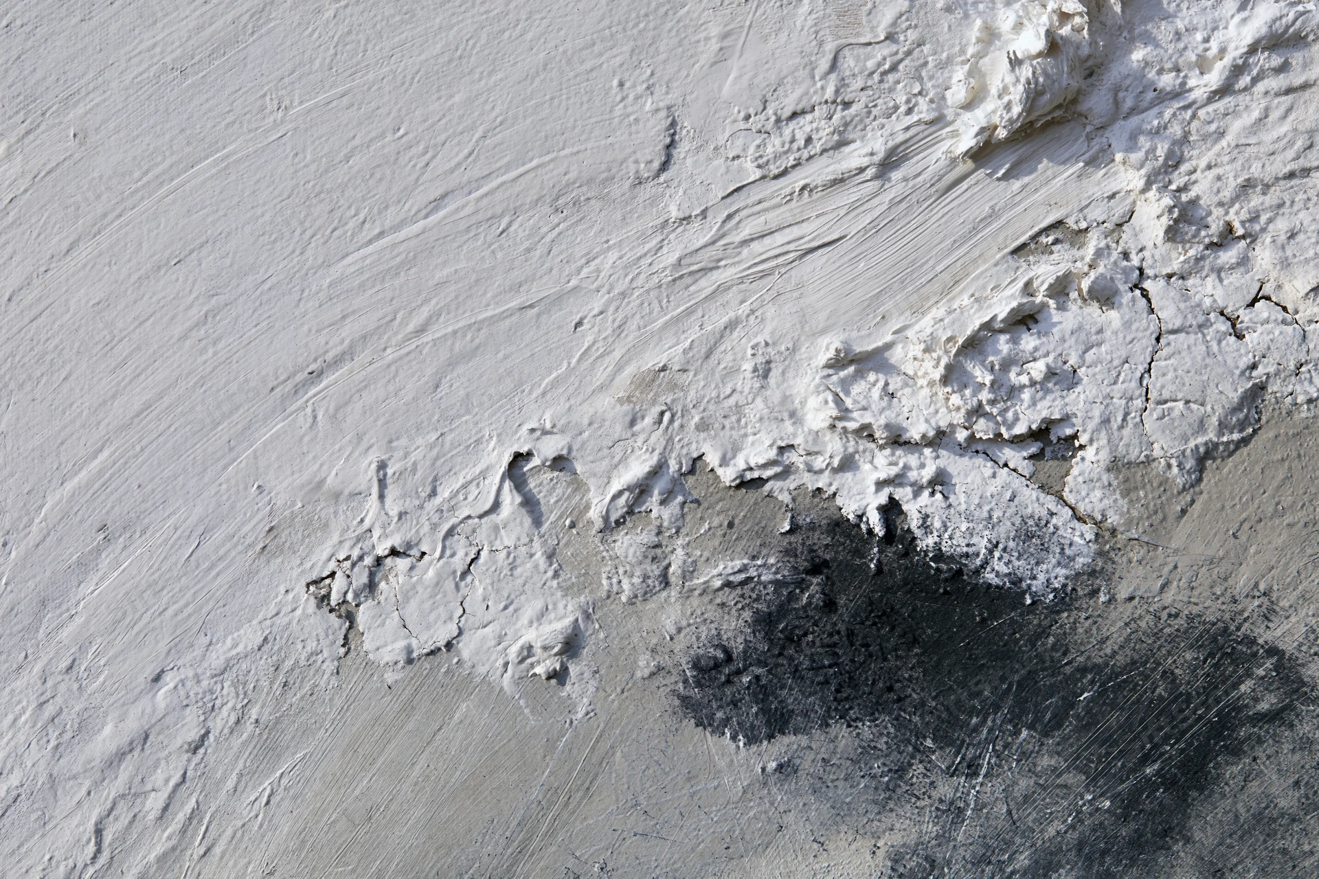 Close-up of abstract painted canvas with textured white gray and black brushstrokes and peeling layers