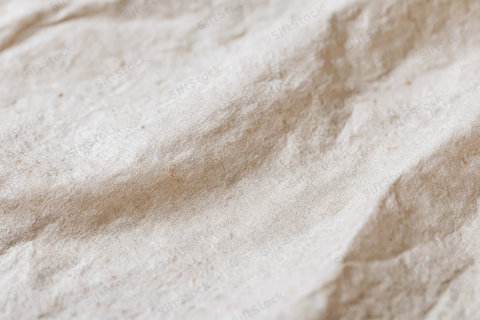Close-up of crumpled cream kraft paper surface with natural texture and folds