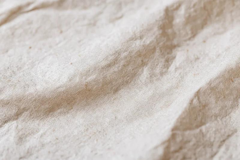 Close-up of crumpled cream kraft paper surface with natural texture and folds