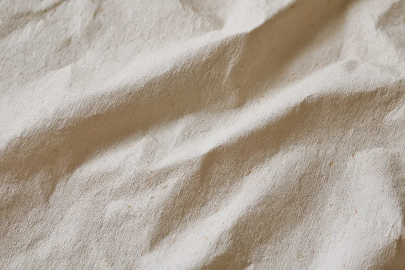 Close-up of crumpled cream kraft paper surface with natural folds and texture