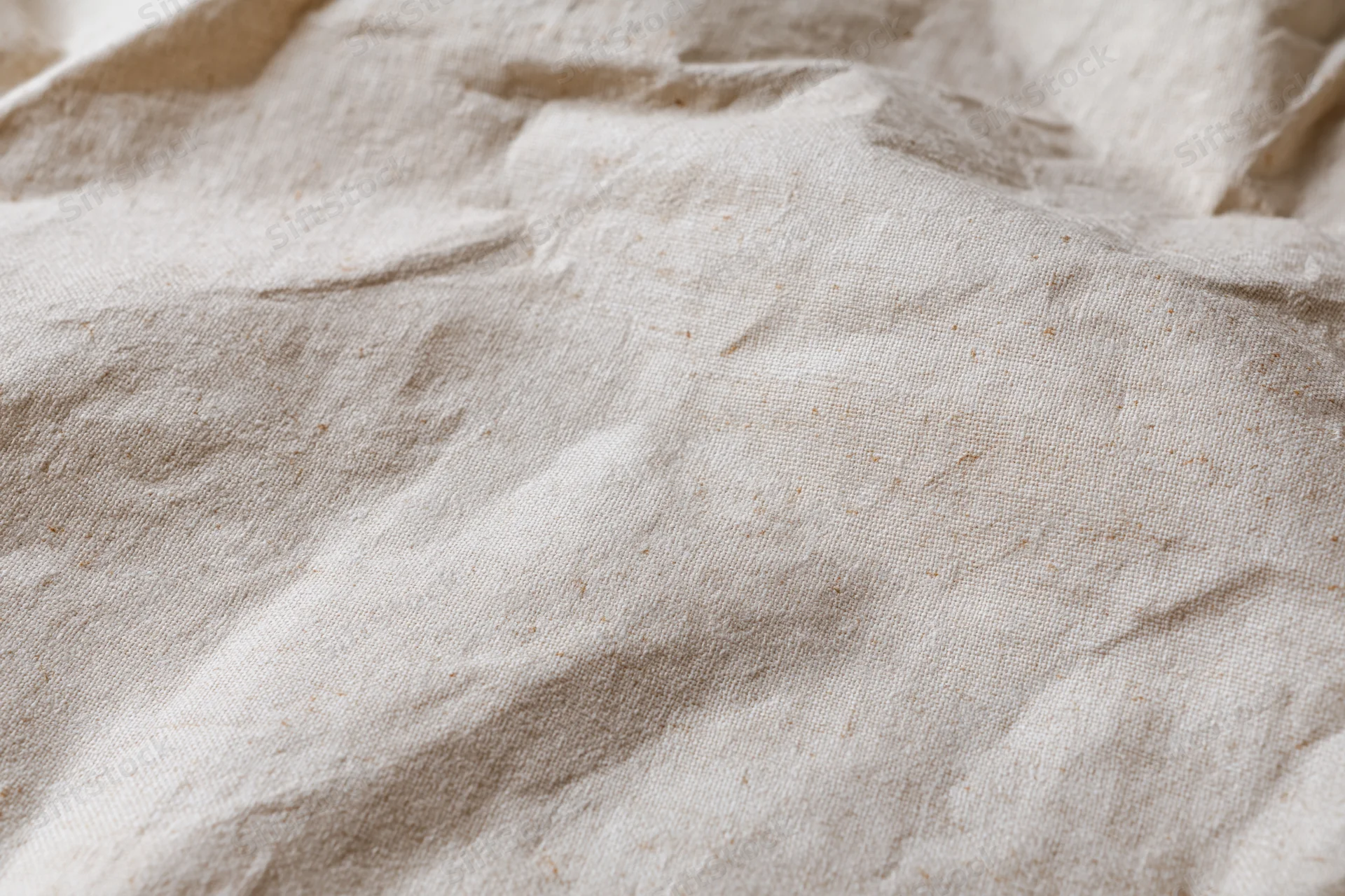 Close-up of crumpled cream kraft fabric texture in flat lay arrangement