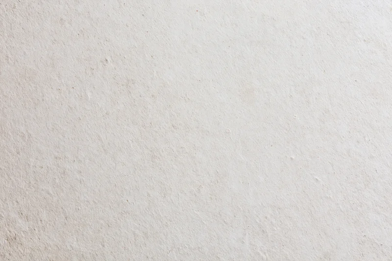 Close-up of a smooth beige plaster wall surface with subtle texture and even lighting