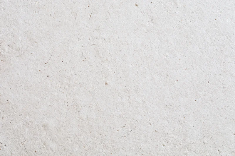 Close-up of a smooth beige plaster wall surface with subtle texture and speckles