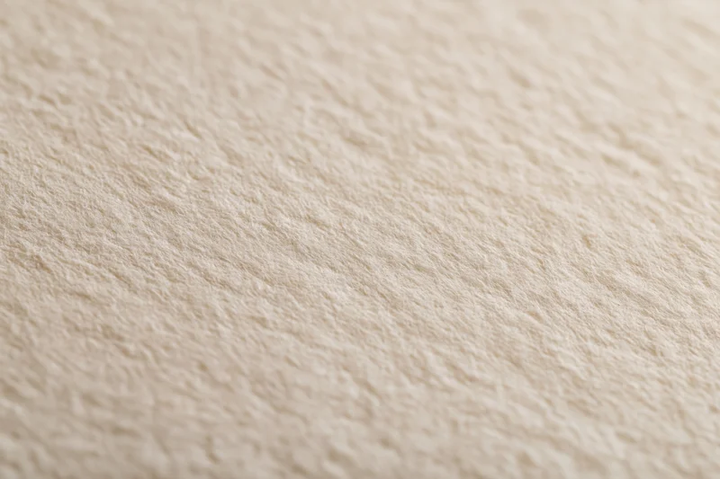 Close-up of aged cream-white paper surface with textured grain filling the frame