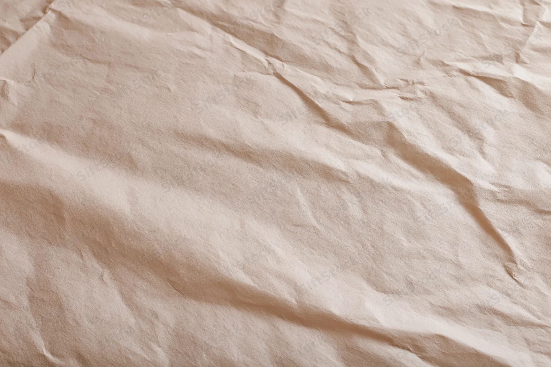 Close-up of crumpled cream wrapping paper with aged texture in flat lay arrangement