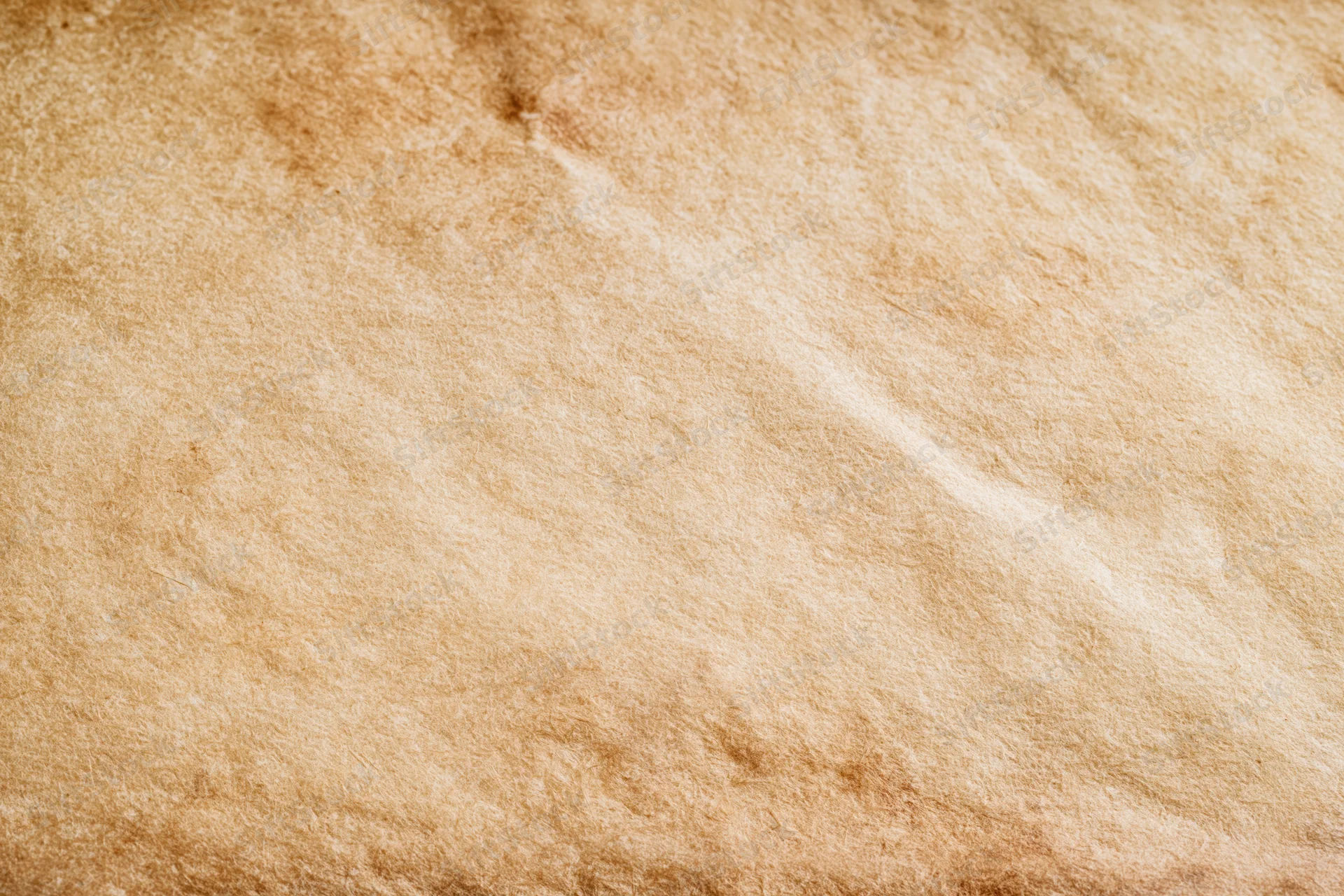 Close-up of aged parchment paper surface with visible fibers and warm brown tones filling the frame