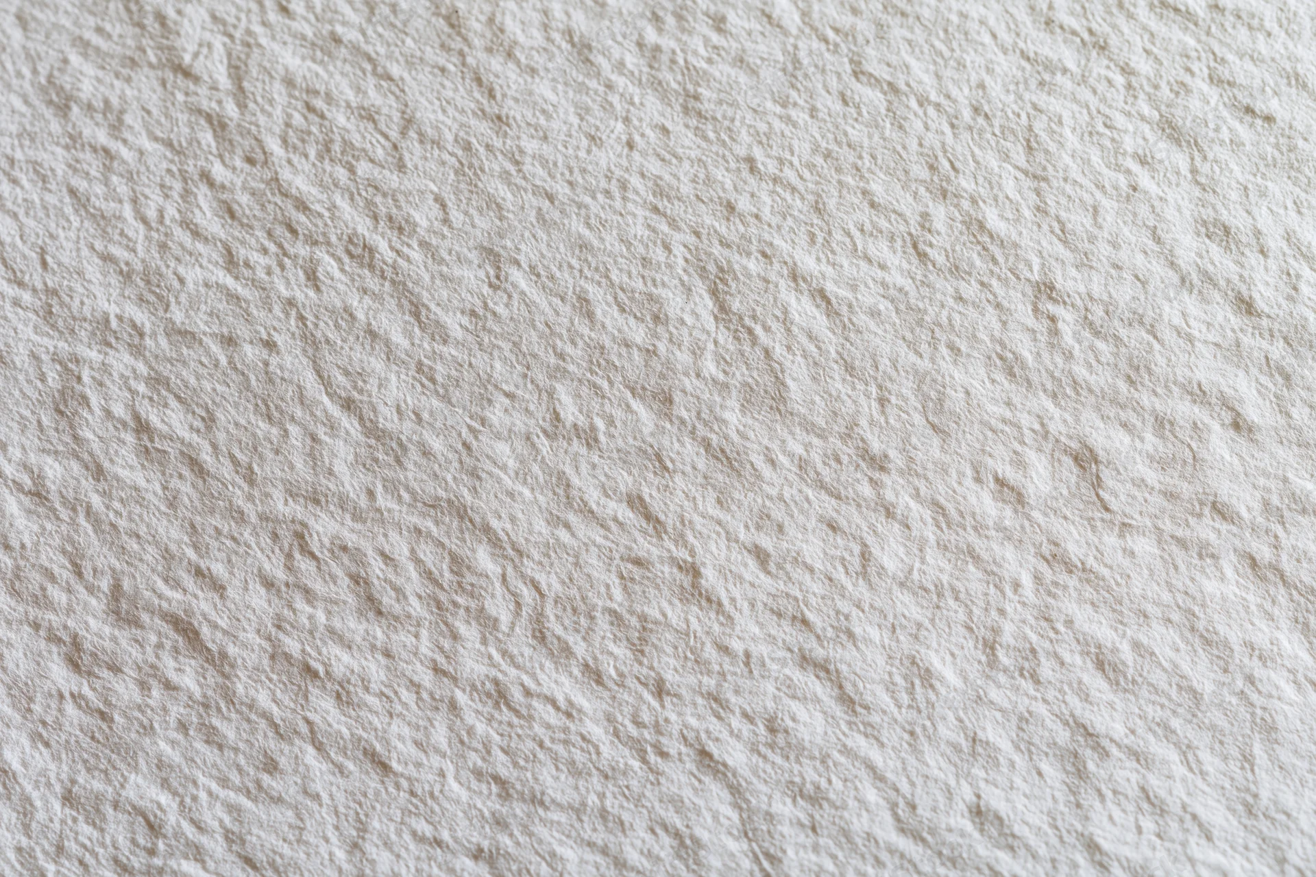 Close-up of blank white watercolor paper surface with textured grain filling the frame