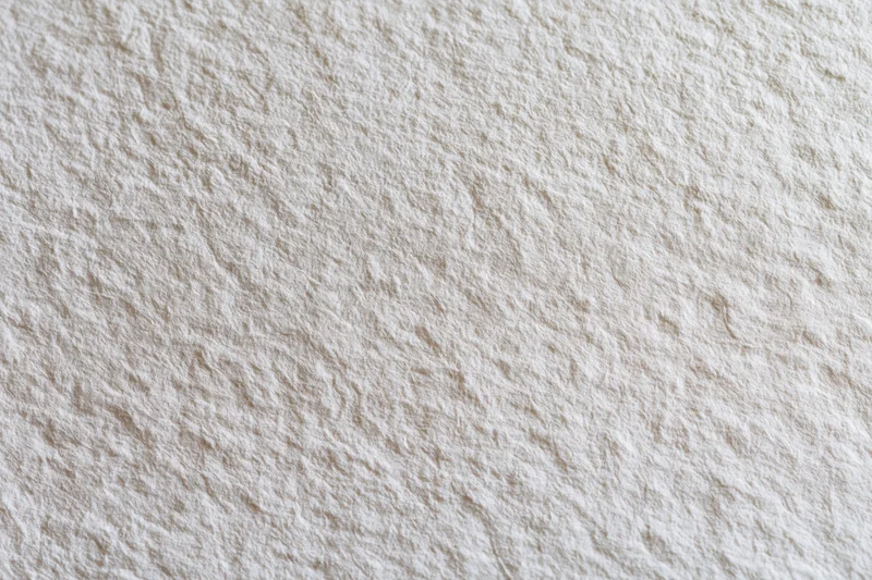 Close-up of blank white watercolor paper surface with textured grain filling the frame