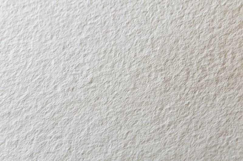Close-up of blank white watercolor paper with textured surface filling the frame