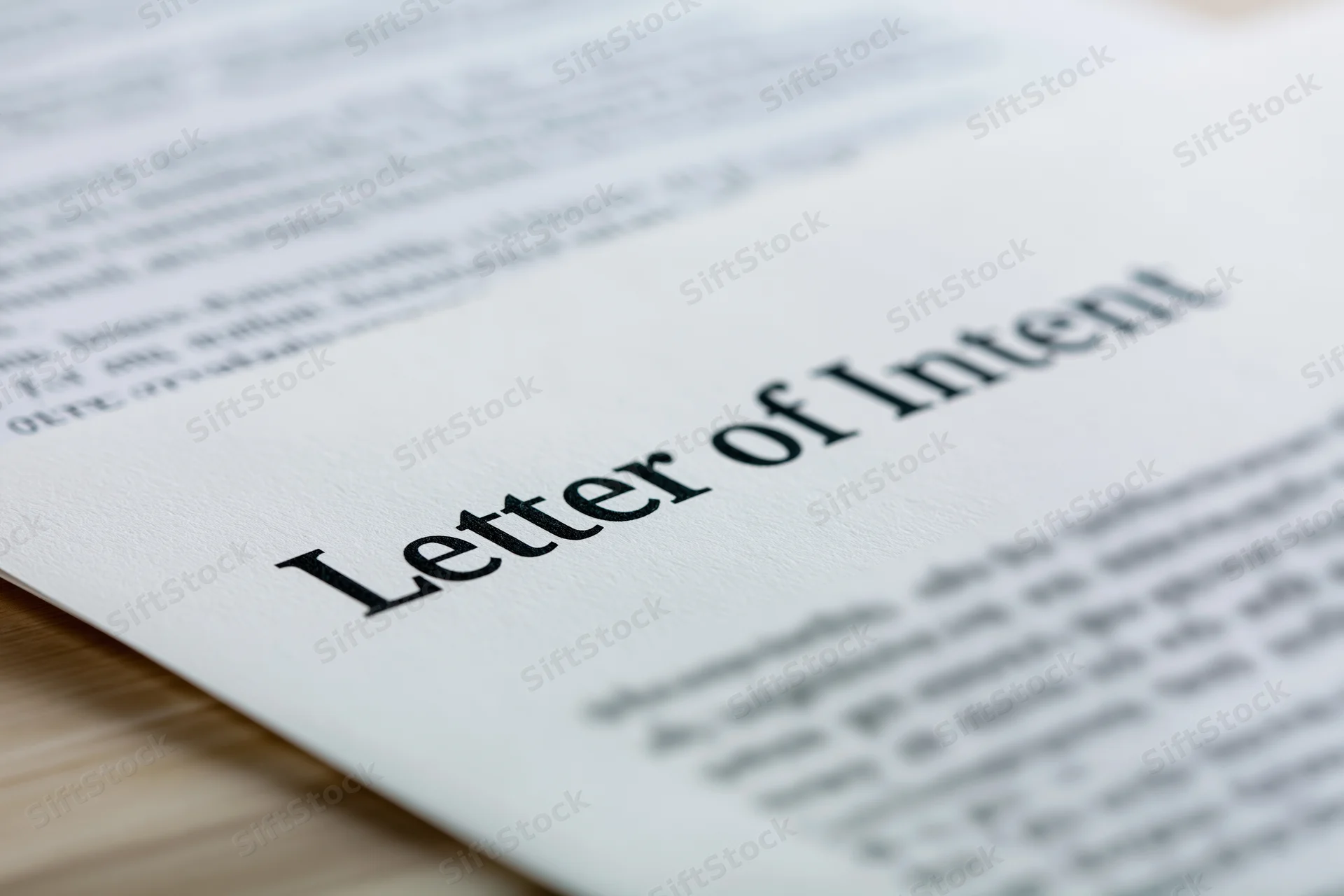 Close-up of a printed business document titled letter of intent on a wooden surface