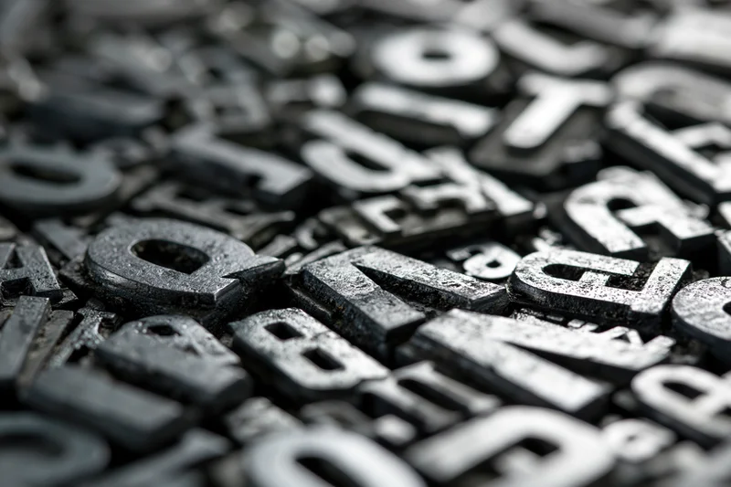 Close-up of vintage metal letterpress type blocks scattered in a pile