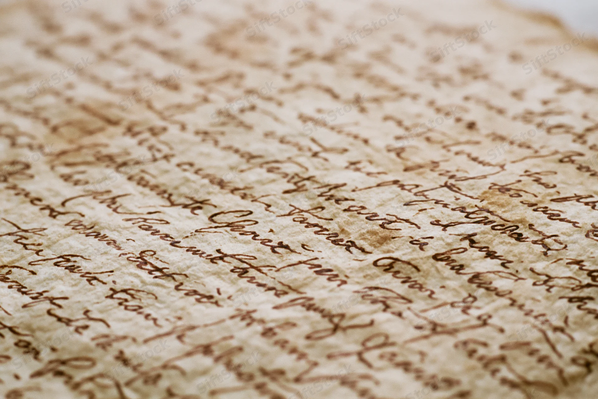 Close-up of aged handwritten manuscript page with flowing cursive script on parchment paper