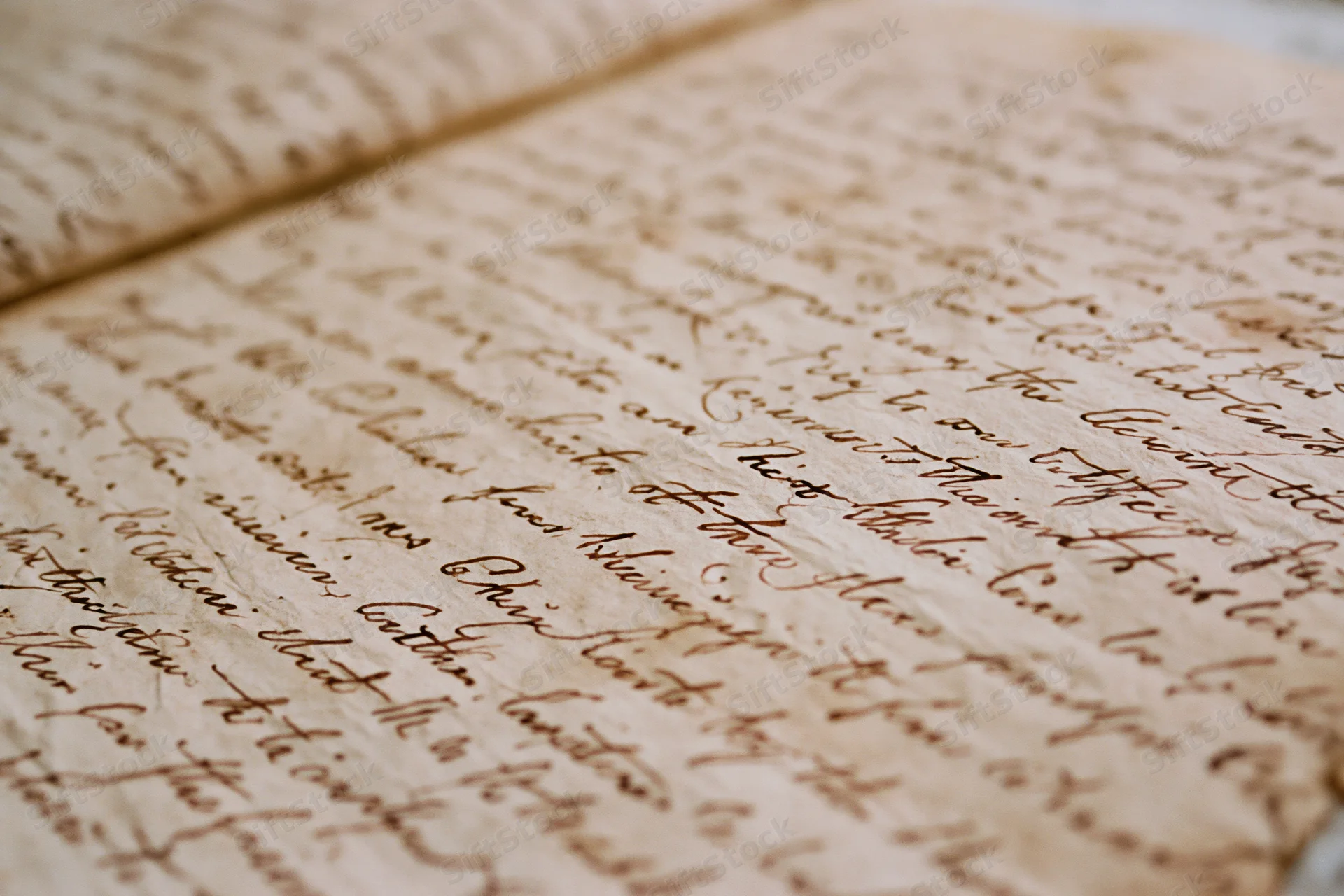 Close-up of aged handwritten manuscript page with flowing cursive script on parchment paper