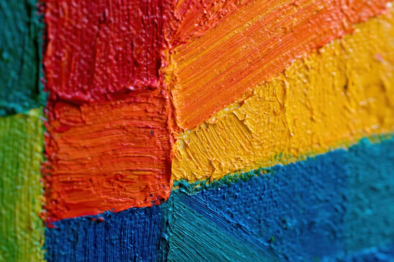 Close-up of thick impasto oil paint strokes on canvas in vibrant colors