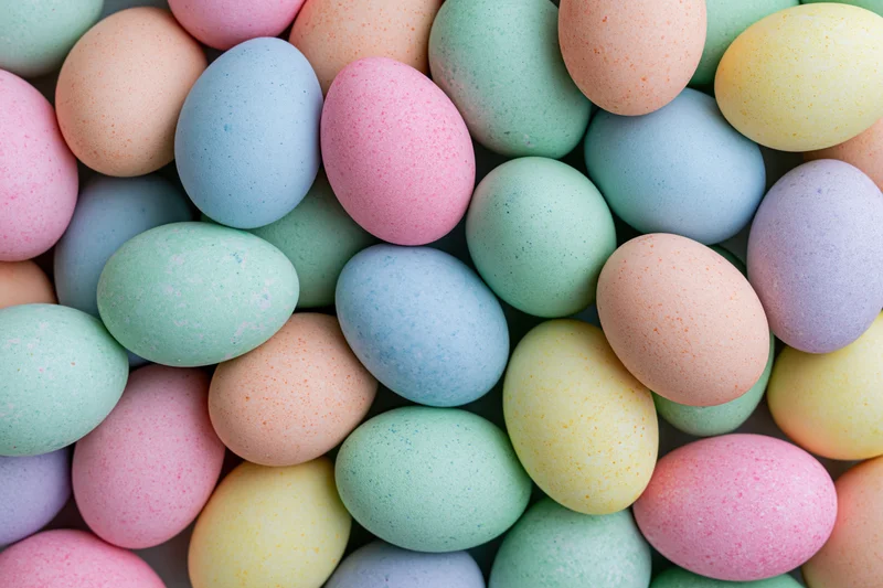 Pastel-colored dyed easter eggs densely packed in a full-frame overhead view