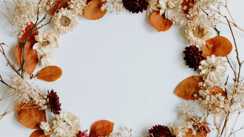 Dried autumn botanicals arranged in a loose wreath on white background with copyspace