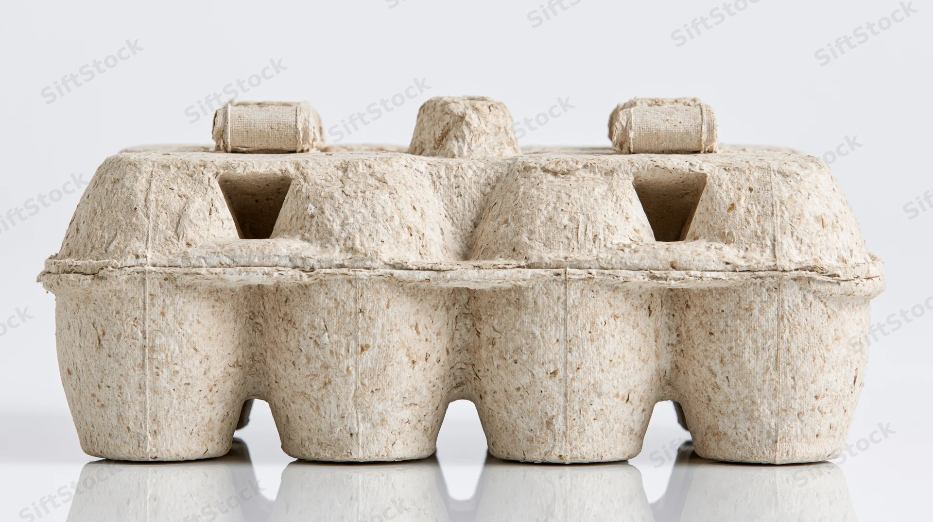 Empty closed cardboard egg carton on reflective white surface