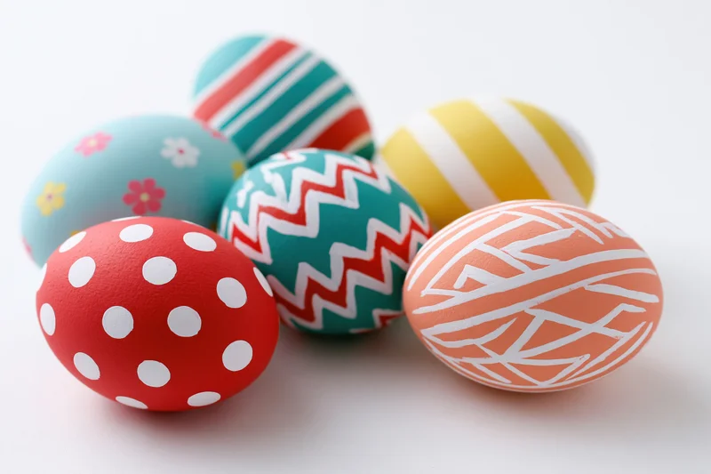 Decorated easter eggs with colorful patterns arranged on a white surface