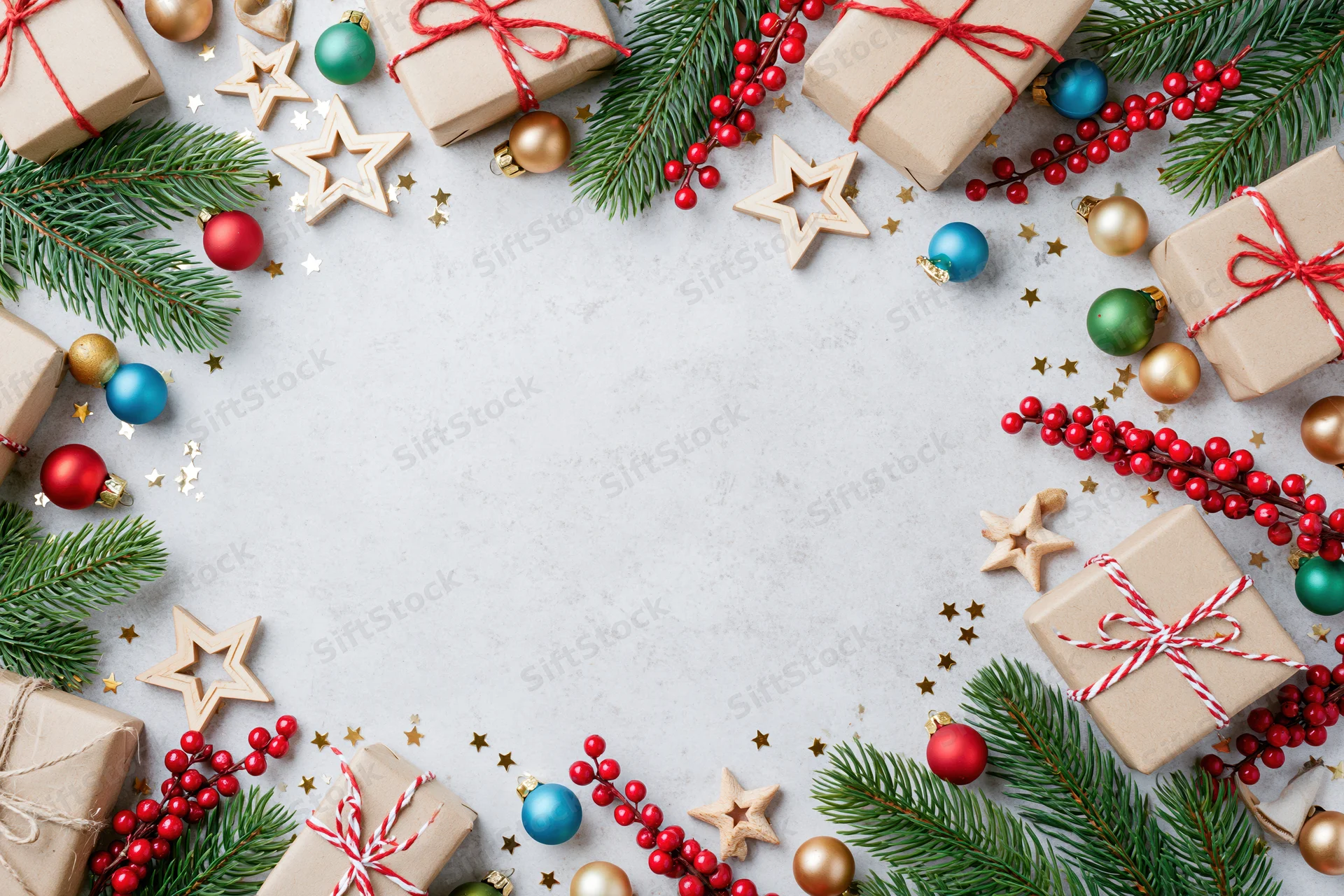 Christmas decorations arranged as a border frame on a light surface with copyspace in center